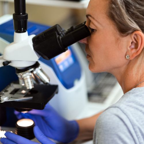closeup of a woman using a microscope
