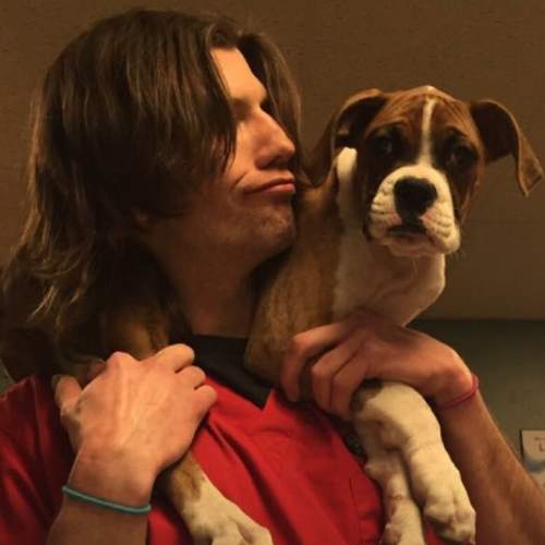 a person in a red shirt holding a dog